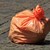Bild von einem vollen orangen Müllsack auf der Straße